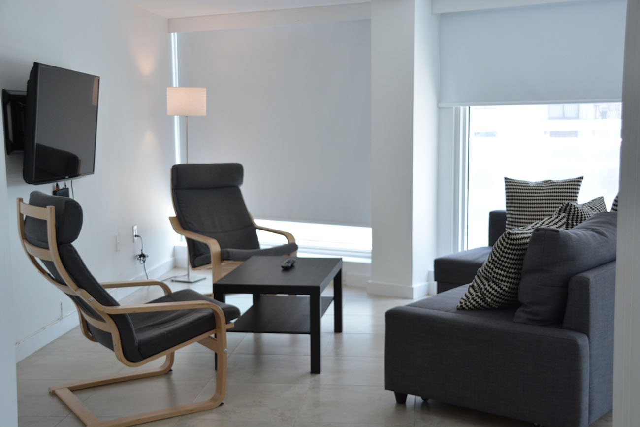 Duplex City View, Living with 2 individual armchairs and armchair with 2 bodies, led tv and two windows overlooking collins avenue
