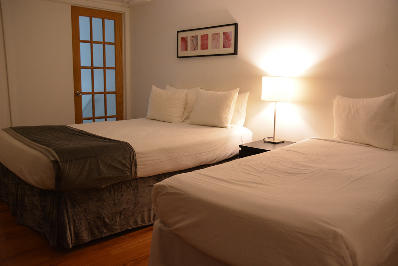 Duplex Ocean View, Bedroom with two beds, warmly lit, wooden floor